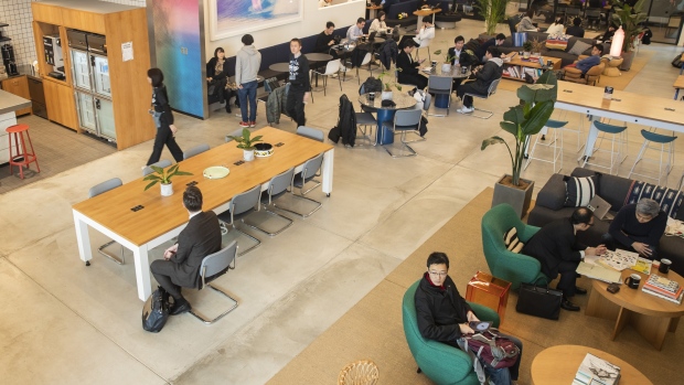 Members sit at the WeWork Cos. Iceberg co-working space in Tokyo. 