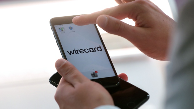 An employee demonstrates the Wirecard AG online payment smartphone app on the company's exhibition