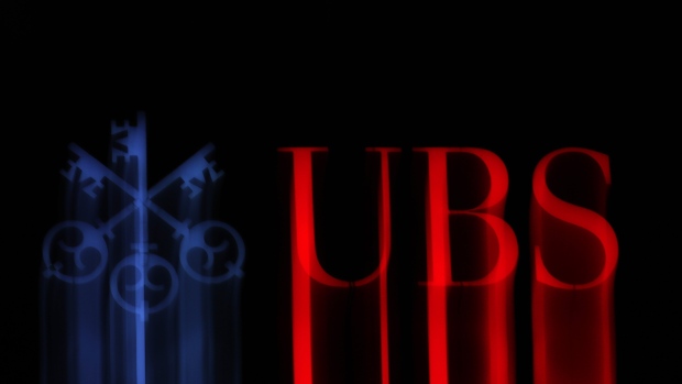 An illuminated company logo is displayed at a UBS Group AG bank branch in Zurich, Switzerland, on Monday, Oct. 14, 2019. The spying scandal roiling Credit Suisse Group AG has also created a big headache at UBS a stone's throw away in Zurich: What to do about its star hire Iqbal Khan. 