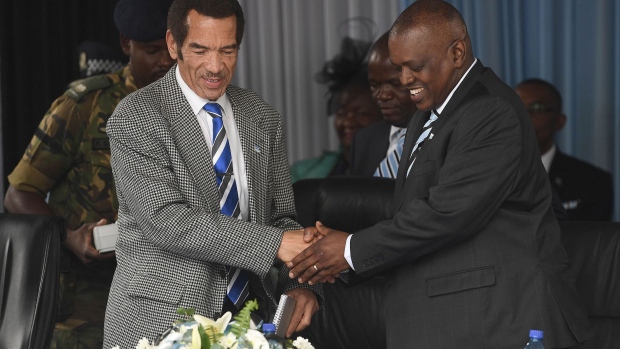 Botswana's President Seretse Ian Khama (L) shakes hands with his vice-president Mokgweetsi Masisi during a rally in his village Serowe on March 27, 2018, before officially stepping down on March 31 and handing power to his vice-president on April 1.
