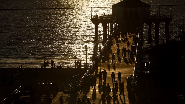 People walk on the pier at sunset in Manhattan Beach, California, U.S. 
