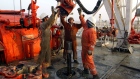 Oil Company workers change pipes on a drilling rig January 22, 2003 on the northern border between Iraq and Kuwait in Kuwait.