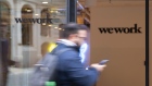 A pedestrian walks past the entrance to the We Work co-working office space. 