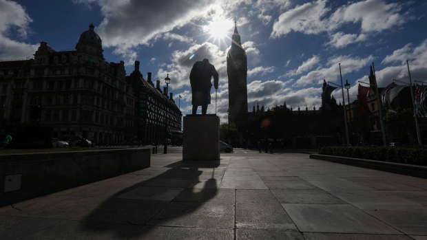 A statue of former Prime Minister Winston Churchill casts a long shadow in front of the Houses of Parliament in London, U.K., on Wednesday, June 7, 2017. Theresa May said she'd be willing to tear up human-rights legislation to combat terrorism in a move the Labour opposition said was an attempt to distract from her cuts to police, as security dominated the closing stages of the U.K. election campaign. 