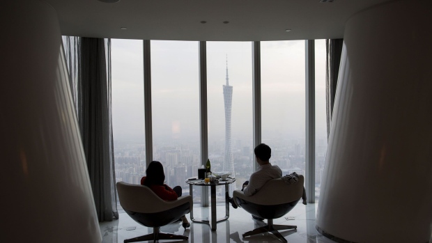 People look out towards the Canton Tower, center, and city skyline from the Tian Bar inside the Four Seasons Hotel in Guangzhou, Guangdong Province, China, on Wednesday, Nov. 20, 2013. New home prices in China’s four major cities rose the most since January 2011, raising concerns of a bubble as home buyers were emboldened by a lack of new nationwide property curbs. 