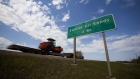 A truck drives past a Suncor Energy Inc. Energy Inc. oil sands road sign near Fort McMurray, Alberta