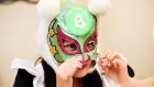 A member of Japanese pop group 'Virtual Currency Girls', wearing a mask with the symbol for the Bitc