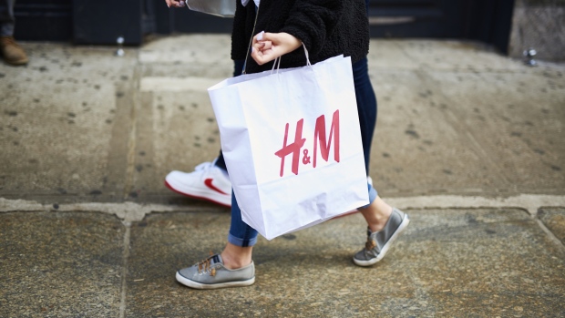 A shopper carries a Hennes & Mauritz AB (H&M) retail bag while walking in the SoHo neighborhood of New York, U.S., on Saturday, March 30, 2019. The U.S. Census Bureau released retail sales figures on April 1. 