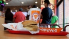 A chicken sandwich sits on a table at a Popeyes as guests wait in line, Aug. 22, 2019, in Kyle, Texa