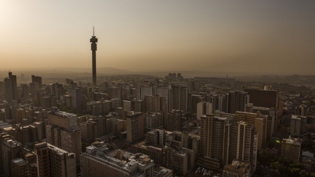 The Hillbrow Tower, operated by Telkom SA SOC Ltd., left, stands on the city skyline at dusk in Johannesburg, South Africa, on Thursday, Oct. 10, 2019. South Africa's economy remains stuck in its longest downward cycle since 1945, adding to pressure on the government to implement reforms to lift business confidence and boost growth. 