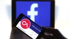 The verified Twitter Inc. page of Cambridge Analytica, displaying their logo and company name, sit on an Apple Inc. iPhone against a backdrop of the Facebook Inc. sign shown on a computer screen in this arranged photograph in London, U.K., on Thursday, March 22, 2018. Facebook Inc.’s co-founder and chief executive officer Mark Zuckerberg has been called to appear before a House panel as fallout continues from revelations that Cambridge Analytica had siphoned data from some 50 million Facebook users as it built a election-consulting company that boasted it could sway voters in contests all over the world. 