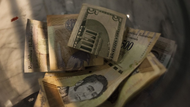 U.S. dollars and Venezuelan bolivares sit in a tip jar at a coffee shop in Caracas. 
