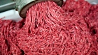 Ground beef exiting a grinder during production.  