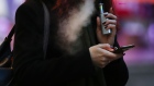 A pedestrian looks at a mobile device while exhaling a cloud of vapour from a vape device in London, U.K., on Thursday, Oct. 17, 2019. Vaping has helped tens of thousands of Britons quit smoking each year, a study showed, underlining the U.K.'s more tolerant stance on the alternative to cigarettes as a backlash grows in the U.S. 