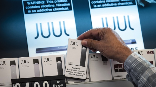 An employee picks up a Juul Labs Inc. device kit for a customer at a store in San Francisco, Califor