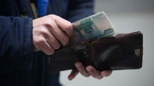 A customer handles 1000 ruble banknotes from a wallet inside a Magnit PJSC hypermarket store in Moscow, Russia, on Wednesday, Feb. 28, 2018. Billionaire Sergey Galitskiy will quit as chief executive officer of Magnit PJSC after selling 138 billion rubles ($2.5 billion) of shares--29 percent of the company--to the state-controlled VTB Group, Magnit said in a regulatory filing. 