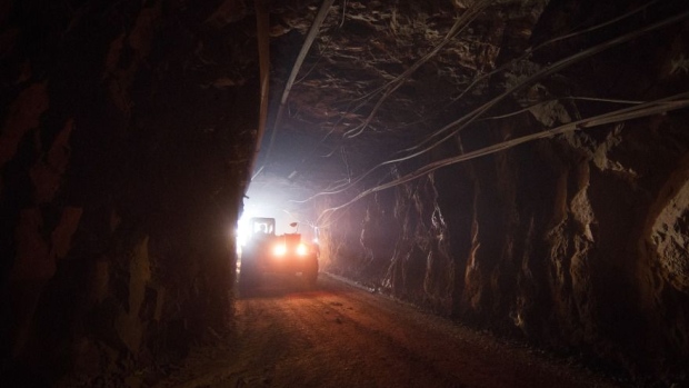 A truck moves through a tunnel to pick up rock ore from the digging floor at the underground gold mine. 