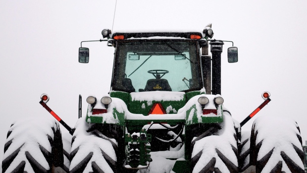 A John Deere tractor is obscured by heavy snowfall in Enid, Okla. Feb. 28, 2015. AP Photo/Enid News 