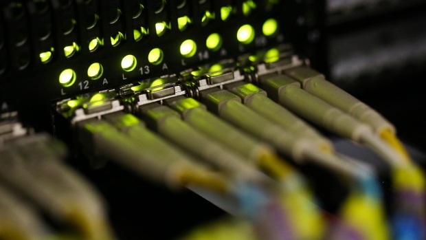 Fibre-optic cables feed into a server inside a comms room at an office in London, U.K., on Friday, Oct. 16, 2015.