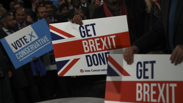 Supporters hold placards ahead of the official launch of the Conservative Party's general election campaign at the National Exhibition Centre in Birmingham, U.K., on Wednesday, Nov. 6, 2019. U.K. prime minister Boris Johnson said he'll be able to get his Brexit deal through Parliament in "a few weeks" if his Conservatives win a majority. 