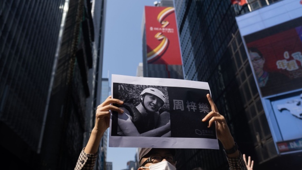A demonstrator holds a placard featuring Chow Tsz-lok on Nov. 8. Photographer: Justin Chin/Bloomberg