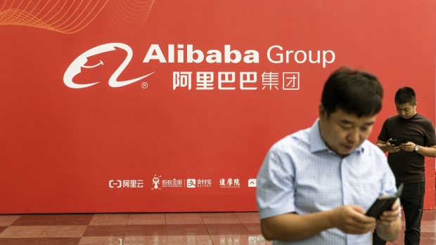 Attendees stand in front of an Alibaba Group Holding Ltd. display wall at the World Artificial Intelligence Conference (WAIC) in Shanghai, China, on Thursday, Aug. 29, 2019. The conference runs through Aug. 31. 
