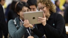People interact with an Apple iPad in Chicago. 
