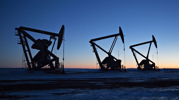 The silhouettes of pumpjacks are seen above oil wells in the Bakken Formation near Dickinson, North Dakota, U.S., on Wednesday, March 7, 2018. When oil sold for $100 a barrel, many oil towns dotting the nation's shale basins grew faster than its infrastructure and services could handle. Since 2015, as oil prices floundered, Williston has added new roads, including a truck route around the city, two new fire stations, expanded the landfill, opened a new waste water treatment plant and started work on an airport relocation and expansion project. 