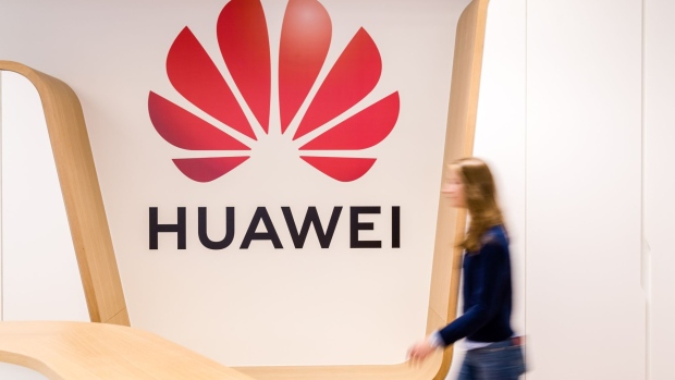 An employee walks past a logo in the reception area of the Huawei Technologies Co. Cyber Security Transparency Centre in Brussels, Belgium, on Monday, April 15, 2019. Huawei's ability to make inroads into Europe's future telecom infrastructure may be more about regulatory hurdles than outright bans. 