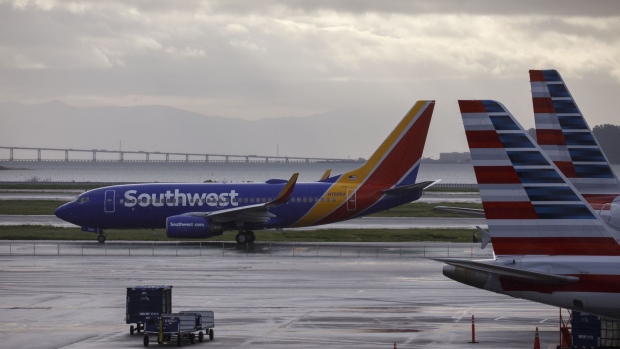 A Southwest Airlines Co. Boeing Co. 737-700 jet aircraft taxis on the tarmac at San Francisco International Airport (SFO) in San Francisco, California, U.S., on Wednesday, March 27, 2019. The ban on Boeing 737 Max flights plus soft leisure-travel demand will shave $150 million from Southwest's first-quarter revenue. 