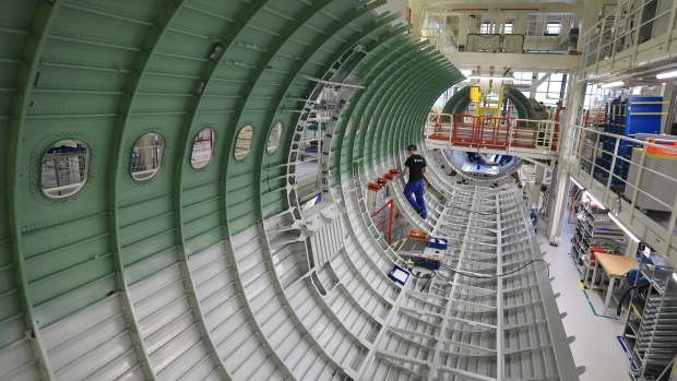 An employee works on a section of fuselage inside the new Airbus SE A320 passenger aircraft family assembly line hangar in Hamburg, Germany, on Tuesday, Oct. 1, 2019. An escalating battle over aircraft subsidies between the U.S. and the European Union threatens to damage both sides, said Airbus Chief Executive Officer Guillaume Faury. 