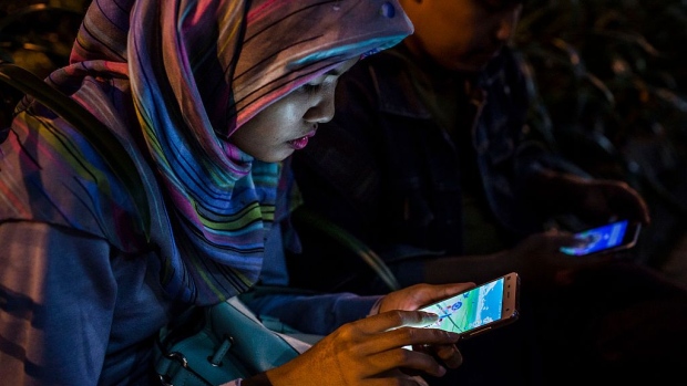 YOGYAKARTA, INDONESIA - JULY 24: An Indonesian Muslim woman, Raditya, plays Pokemon Go game on her smartphone on July 24, 2016 in Yogyakarta, Indonesia. "Pokemon Go," which uses Google Maps and a smartphone has been a smash-hit in countries where it is available and already popular in Indonesia even though it has not been officially released. Indonesians have been downloading the game by using a proxy location which gives them access to app stores of other countries as security officials have voiced worries that the game could pose a security threat. (Photo by Ulet Ifansasti/Getty Images)