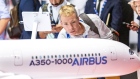 An attendee inspects an Airbus SE A350-1000 scale model aircraft in the Airbus pavilion.