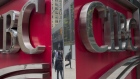 Pedestrians are reflected in signage on the exterior of the Canadian Imperial Bank of Commerce (CIBC) headquarters building in Toronto, Ontario, Canada, on Friday, May 19, 2017. Ontario is easing rules for its pension funds as years of low interest rates, poor equity returns and a looming retiree glut pressure companies. 