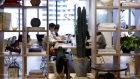 Members sit around a communal working table inside the WeWork office space in Yokohama, Japan. 