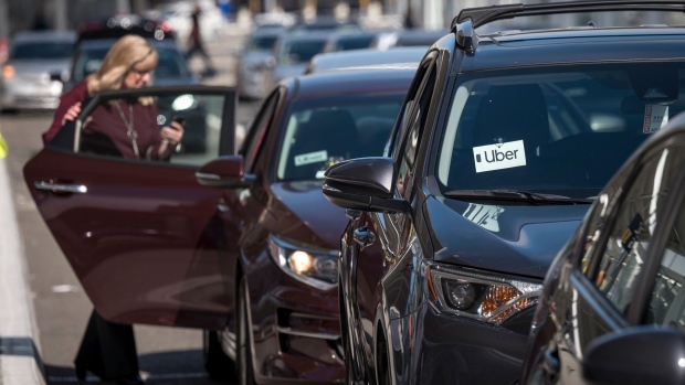 A traveler gets into a car displaying Uber Technologies Inc. signage at the Oakland International Airport in Oakland, California, U.S., on Tuesday, Aug. 6, 2019. Uber Technologies Inc. is scheduled to release earnings figures on August 8. 