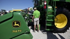 An attendee views a Deere & Co. John Deere brand combine harvester at the company's booth during the Farm Progress Show in Decatur, Illinois, U.S., on Wednesday, Aug. 28, 2019. 