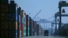 A truck drives past stacks of shipping containers at the Port of Oakland on November 18, 2019 in Oakland, California. 