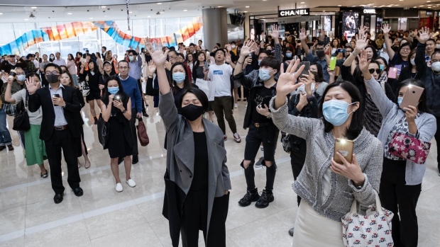 Demonstrators raise their hands during a lunch time flash mob protest at the International Finance Center (IFC) Mall in the Central district of Hong Kong, China, on Tuesday, Nov. 26, 2019.