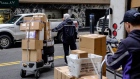 A driver for an independent contractor to FedEx Corp. pushes a cart with packages for delivery in New York, U.S., on Monday, Nov. 26, 2018. Americans spent $50.6 billion online this month through Sunday, a 20 percent increase from a year ago and spearheaded by a 24 percent surge to $6.2 billion on Black Friday, according to Adobe Analytics. Cyber Monday is expected to add another $7.8 billion -- an 18 percent year-over-year gain for that day. 