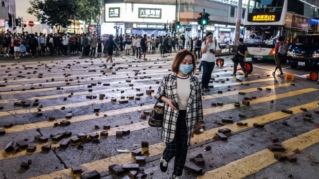 Pedestrians walk over scattered bricks during a protest in Causeway Bay, Hong Kong on Nov. 12. Photographer: Justin Chin/Bloomberg