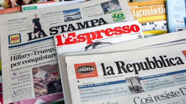 A copy of the La Stampa newspaper published by Fiat Chrysler Automobiles NV's Itedi Spa unit, sits underneath a copy of weekly magazine L'Espresso and daily newspaper la Repubblica, both published by L'Espresso on a news stand in this arranged photograph in Rome, Italy, on Thursday, March, 3, 2016. Fiat Chrysler Automobiles NV and publisher Gruppo Editoriale L'Espresso SpA are combining editorial assets in a bid to create the "leading player" in the Italian publishing industry. 