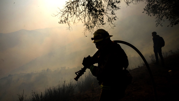 A firefighter walks through smoke from forest wildfires in California. Bloomberg