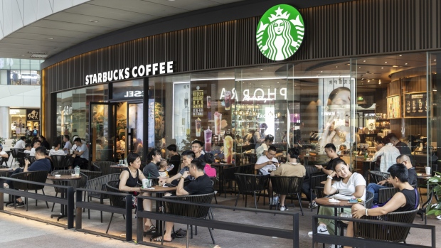 Customers sit outside a Starbucks Corp. coffee shop in Xiamen, China, on Monday, Aug. 26 2019.