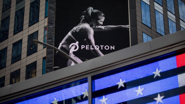 A monitor displays Peloton Interactive Inc. signage during the company's initial public offering (IPO) across from the Nasdaq MarketSite in New York, U.S., on Thursday, Sept. 26, 2019. Peloton fell as much as 9.5% Thursday after raising $1.16 billion in its U.S. initial public offering, becoming the latest unprofitable startup to fail win over investors in its trading debut. 