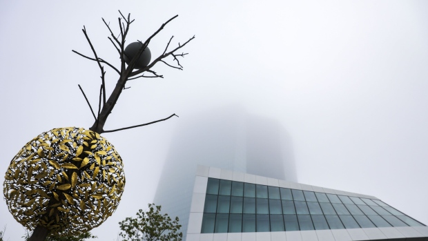 A bronze and granite tree-shaped sculpture entitled Gravity and Growth stands beside the fog shrouded European Central Bank (ECB) headquarters ahead of a farewell ceremony for ECB President Mario Draghi in Frankfurt, Germany, on Monday, Oct. 28, 2019. Christine Lagarde will inherit two gifts when she takes over the presidency of the European Central Bank, both temporary and both from Draghi. 