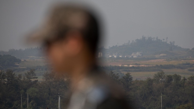 A South Korean soldier stands guard as North Korea's Gijungdong village is seen in the background during a media tour of Daeseong-dong village in the Demilitarized Zone (DMZ) of Paju, South Korea, on Monday, Sept. 30, 2019. KT Corp., the largest telecommunication company in South Korea, began providing 5G network service to the village in June. 