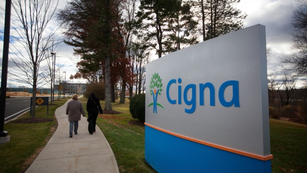 Pedestrians walk passed signage at Cigna Corp. headquarters in Bloomfield, Connecticut, U.S., on Tuesday, Nov. 22, 2016. Anthem Inc.'s proposed $48 billion merger with Cigna Corp. could give the insurer the power to raise prices for employers both in the 14 states where it does business, as well as across the country, according to a witness in the U.S. government's lawsuit to block the deal. 