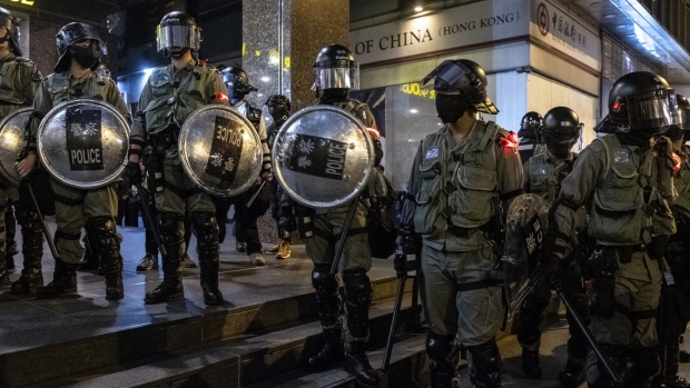 Riot police stand guard in front of a Bank of China Ltd. branch following the "Thanksgiving Day Assembly for Hong Kong Human Rights and Democracy Act" in the Central district of Hong Kong, China, on Thursday, Nov. 28, 2019. Donald Trump signed legislation expressing U.S. support for Hong Kong protesters, prompting China to threaten retaliation just as the two nations get close to signing a phase one trade deal. 