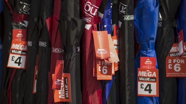 Discounted umbrellas sit on display outside a Sports Direct International Plc store in Crayford, U.K. on Monday, July 29, 2019. Sports Direct plunged after the U.K. retailer reported a surprise tax bill of almost $750 million, the departure of its financial chief and deepening woes at department-store chain House of Fraser. 
